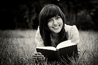 Girl in meadow reading book